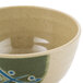 A close-up of a GET Japanese Traditional bowl with a green and blue design on a white surface.