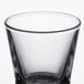 A close up of a clear Libbey shot glass with a black rim.