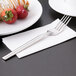 A Libbey stainless steel dessert fork on a napkin with strawberries.