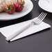 A Libbey Cimarron stainless steel utility fork on a napkin next to strawberries.