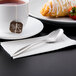 A cup of tea with a Libbey Contempra stainless steel teaspoon on a napkin.