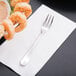 A Reserve by Libbey stainless steel cocktail fork with shrimp on a napkin.
