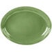 A green oval porcelain platter with a wavy edge.