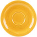 A yellow saucer with a circular pattern on the rim.