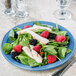 A blue Libbey Cantina porcelain plate with a salad of spinach, berries, and chicken.