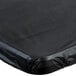 A black rectangular plastic tablecloth with elastic on a table.