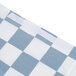 A close-up of a blue and white checkered plastic bag with a Creative Converting Stay Put Black Check tablecloth inside.