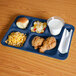 A navy blue Cambro compartment tray with food on it.