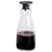 An Arcoroc glass carafe filled with a brown liquid and a stopper.