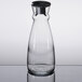 An Arcoroc clear glass carafe with a black stopper.