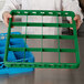 A chef using a green Carlisle OptiClean glass rack extender with green plastic dividers.