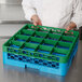 A chef holding a green Carlisle OptiClean glass rack extender on a tray.