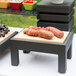 A Vollrath display table with food on a cutting board.
