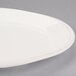 An oval ivory porcelain platter with a rim.
