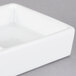 A white square porcelain tray with 4 compartments.