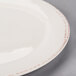 A Libbey medium rim porcelain plate with an ivory center and brown rim.