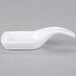 A white spoon shaped dish with a white bowl and handle.