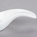 A Libbey white porcelain spoon with a curved handle.