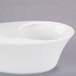 A Libbey white porcelain bar snack dispenser bowl with a hole in the bottom on a white background.