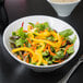 A Libbey Belmar bowl filled with salad with yellow peppers and carrots.