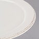 A close up of a Libbey ivory porcelain plate with a medium rim.