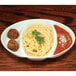 A Libbey white porcelain divided platter with spaghetti and meatballs on it.