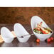 Three Libbey white porcelain bowls filled with salad and a bowl of grilled chicken salad with a fork.