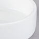 A close up of a Libbey ultra bright white porcelain disk bowl on a white surface.