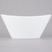 A Libbey ultra bright white porcelain Neptune bowl with a curved edge on a white background.