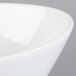A close-up of a Libbey Ultra Bright White Neptune bowl with a curved rim.