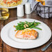 A Libbey Farmhouse ivory porcelain plate with salmon, green beans and pasta on a table.