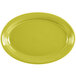A lemongrass yellow oval Fiesta china platter with a rim.