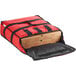 A red ServIt insulated pizza delivery bag holding two pizza boxes.