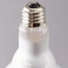 A close up of a Satco halogen flood light bulb with a white light.