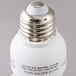 A close-up of a Satco warm white mini spiral compact fluorescent light bulb with a silver cap.