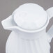 A white Vollrath SwirlServe hot and cold beverage server with a lid and handle.