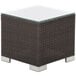 A BFM Seating square wicker end table with glass top.