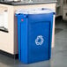 A blue Rubbermaid Slim Jim recycling bin with a white recycling logo.