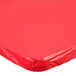 A red Creative Converting rectangular plastic tablecloth with elastic on a table.