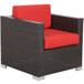 A BFM Seating Aruba Java wicker outdoor armchair with red cushions.