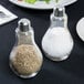 An American Metalcraft glass lightbulb salt and pepper shaker set on a table.
