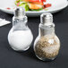 Two American Metalcraft glass lightbulb salt and pepper shakers on a table.