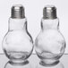 Two American Metalcraft glass lightbulb salt and pepper shakers with a clear glass top.