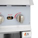A close-up of the control panel of a white Cooking Performance Group natural gas range with a knob.