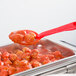 A red Cambro salad bar spoon over a bowl of meatballs.