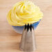A close-up of a yellow frosted cupcake with an Ateco Open Star tip.
