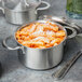 A Clipper Mill stainless steel mini bistro serving pot filled with pasta and sauce on a table.