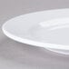A close up of an Elite Global Solutions white melamine platter with a rim.