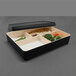 A black rectangular Elite Global Solutions Karma Bento Box with a white tray of food.