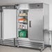 An Avantco stainless steel reach-in refrigerator with shelves and food in it.